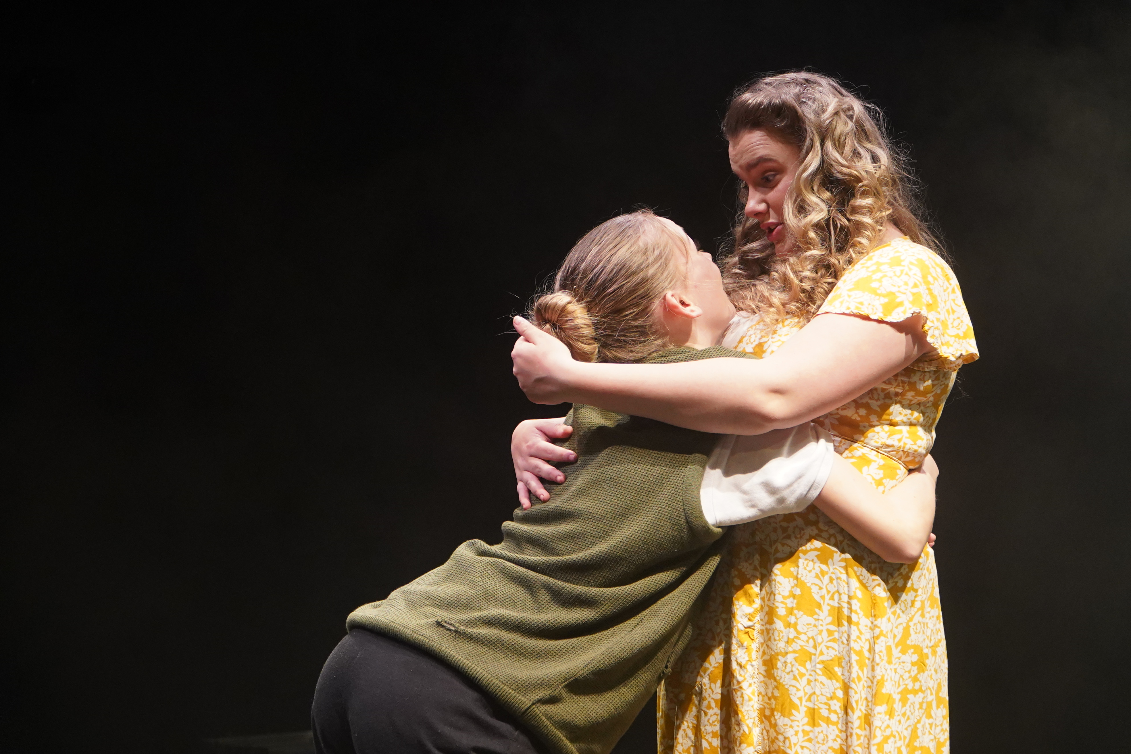 Mickey and Mrs Johnstone hugging in the play blood brothers