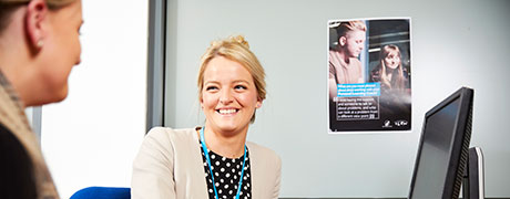 A woman smiling at a man next to a computer