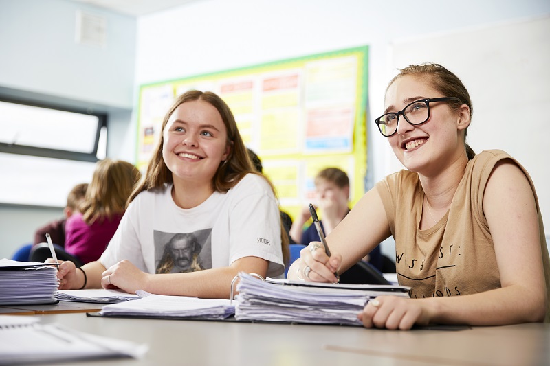 Students sitting at a table taking notes