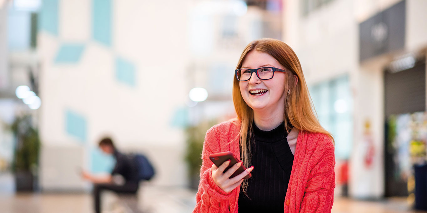 Happy student with her mobile phone